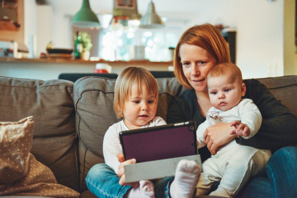 While You Were Fighting Each Other, mom looking at iPad with her children